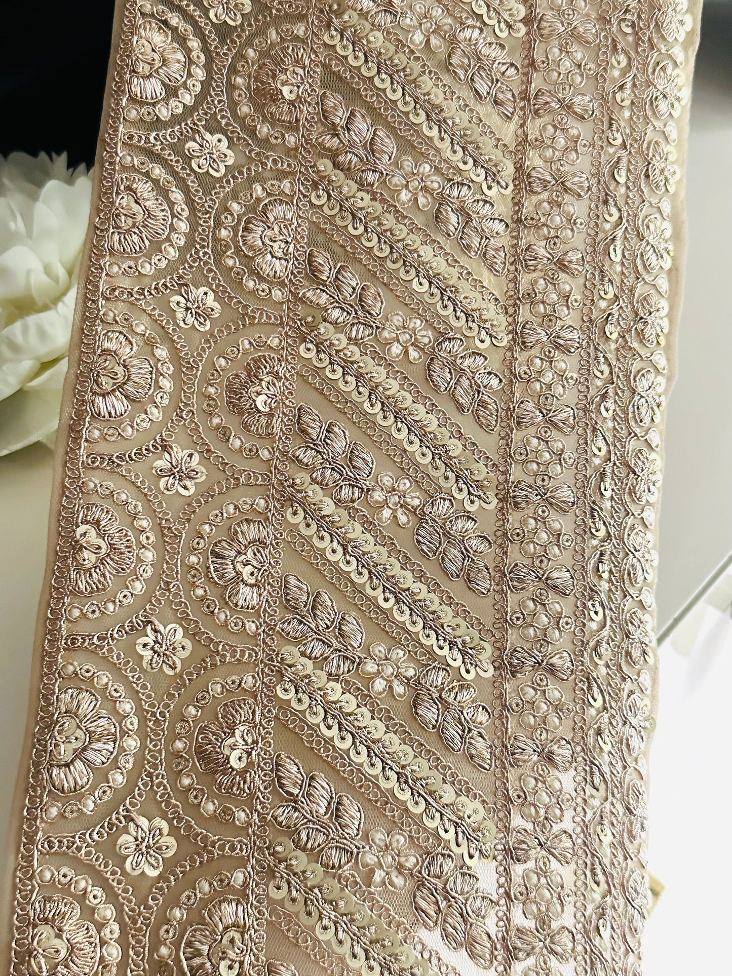 "Shimmering gold lace trim with sequin and zari details, ideal for wedding veils, reception dresses, and ball gowns."
"Luxurious zari and sequin embroidered lace trim for enhancing bridal veils, wedding gowns, and evening wear.