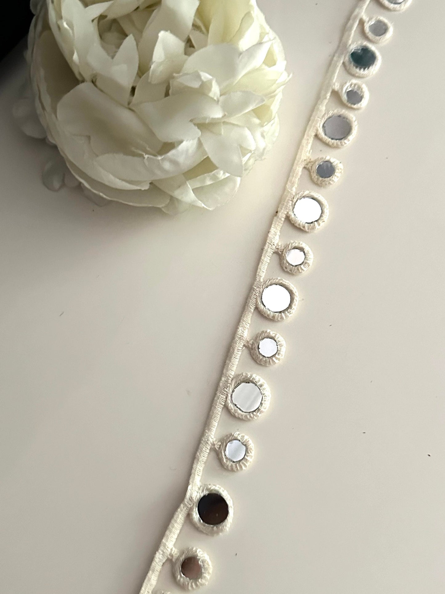 Close-up of a boho choker with cotton geometric mirror trim.