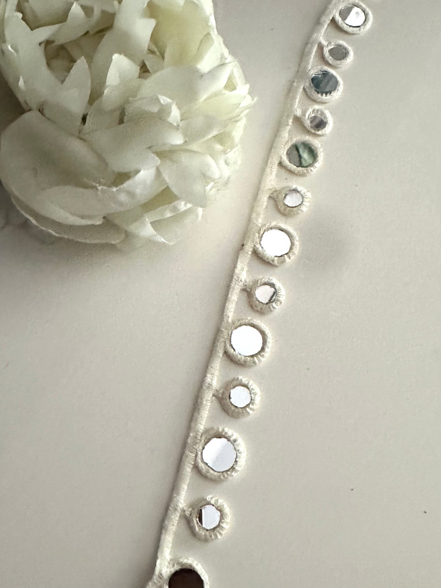 A waist belt decorated with 2cm boho cotton geometric mirror trim.