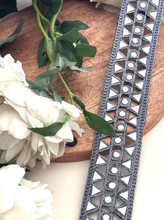 A vintage-inspired denim belt lace trim, adorned with shimmering mirror work, capturing the essence of Indian bohemian style