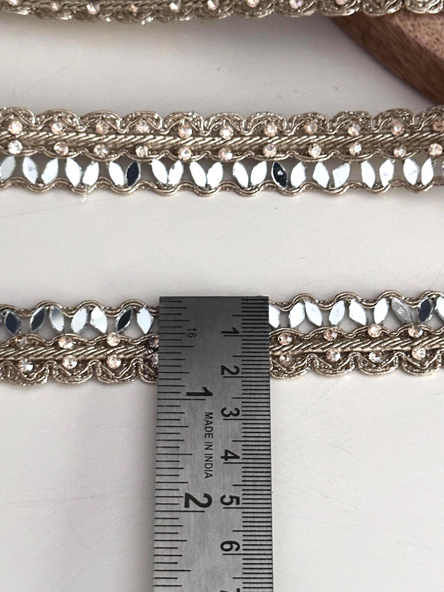 Golden mirror ribbon trim roll with sparkling accents, perfect for bridal gown detailing, lehenga embellishments, or saree edging."