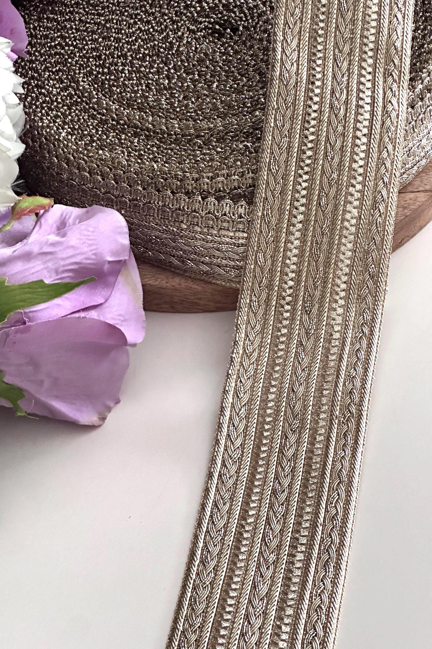 Rolls of gold embroidered lace ribbon, perfect for sewing and embellishments.