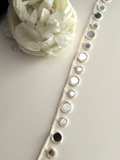 Close-up of a boho choker with cotton geometric mirror trim.