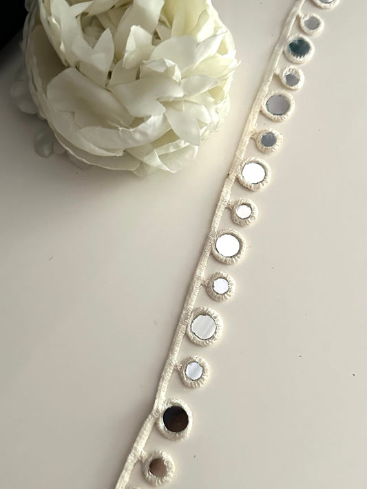 Close-up of a boho choker with cotton geometric mirror trim.