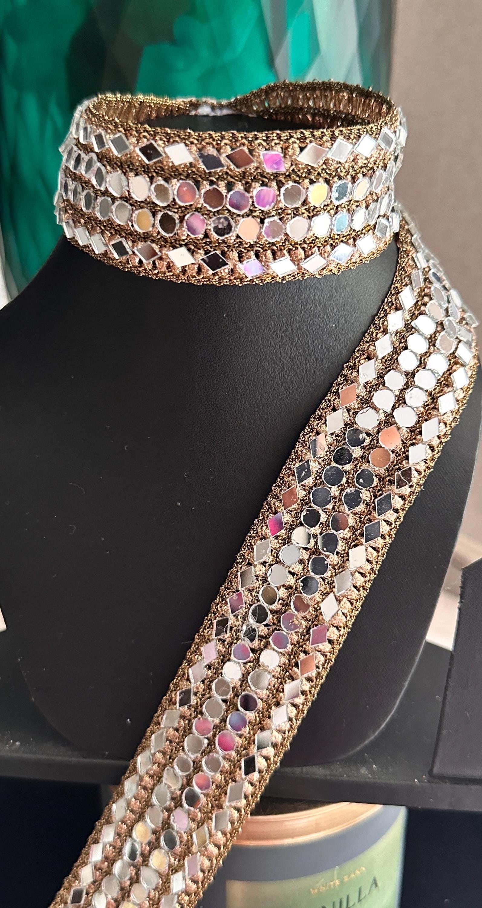 Antique Indian zari mirror belt with intricate mirror work. Geometric cut design adds a touch of vintage elegance. High-quality fabric and mirror work ensure durability and longevity. Adjustable to fit different waist sizes, I