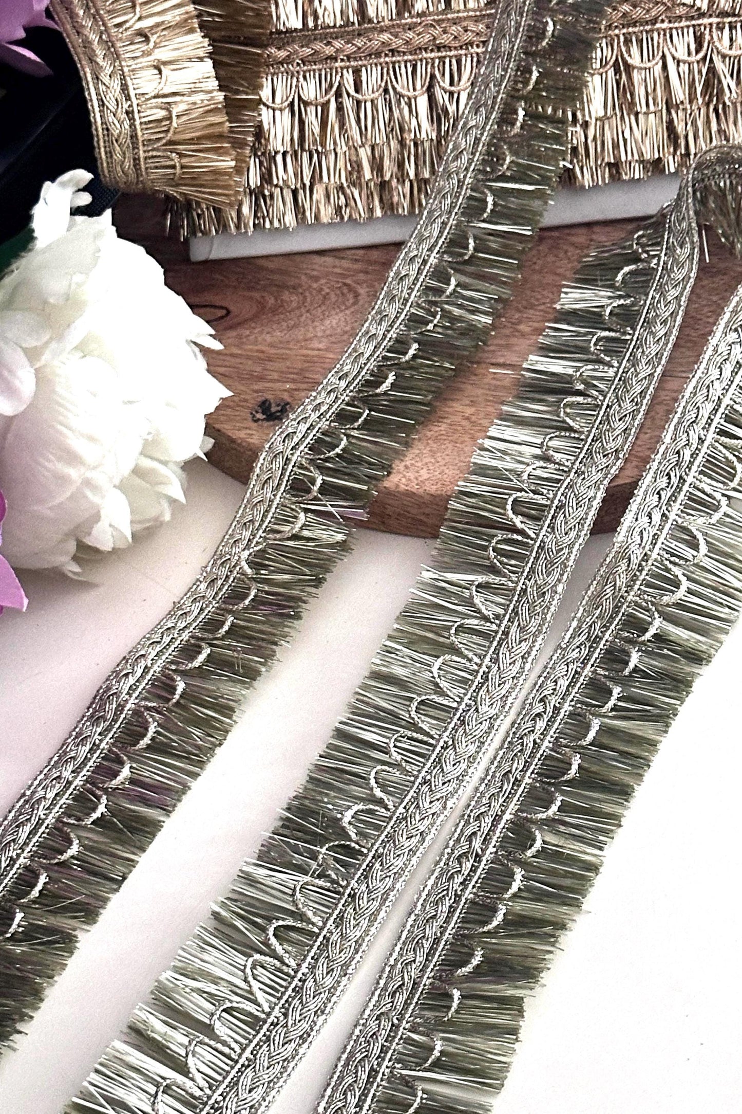 Elegant gold embroidered trim displayed on a spool for fabric embellishment and DIY crafts.