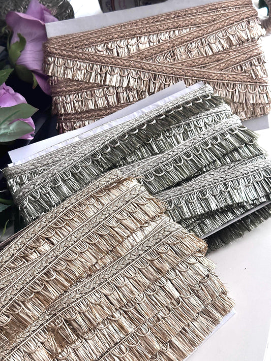 Gold metallic embroidered ribbon trim with intricate woven patterns and textured finish.