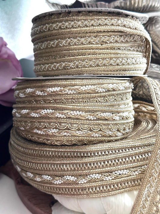 Close-up of gold beaded and metallic embroidered ribbons with intricate patterns.