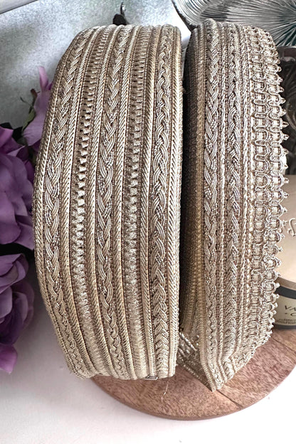 Close-up of gold metallic embroidered ribbon trim with intricate woven patterns.
Luxurious gold craft lace ribbon for sewing, wedding décor, and DIY projects.