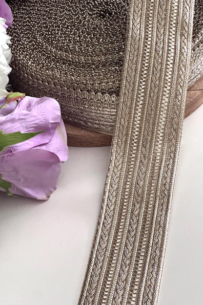Rolls of gold embroidered lace ribbon, perfect for sewing and embellishments.