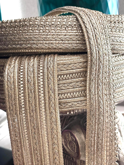 Elegant gold decorative trim with a textured finish for costumes and crafts.
Rolls of gold embroidered lace ribbon, perfect for sewing and embellishments.
Shimmering gold metallic trim displayed on fabric rolls for crafting and design