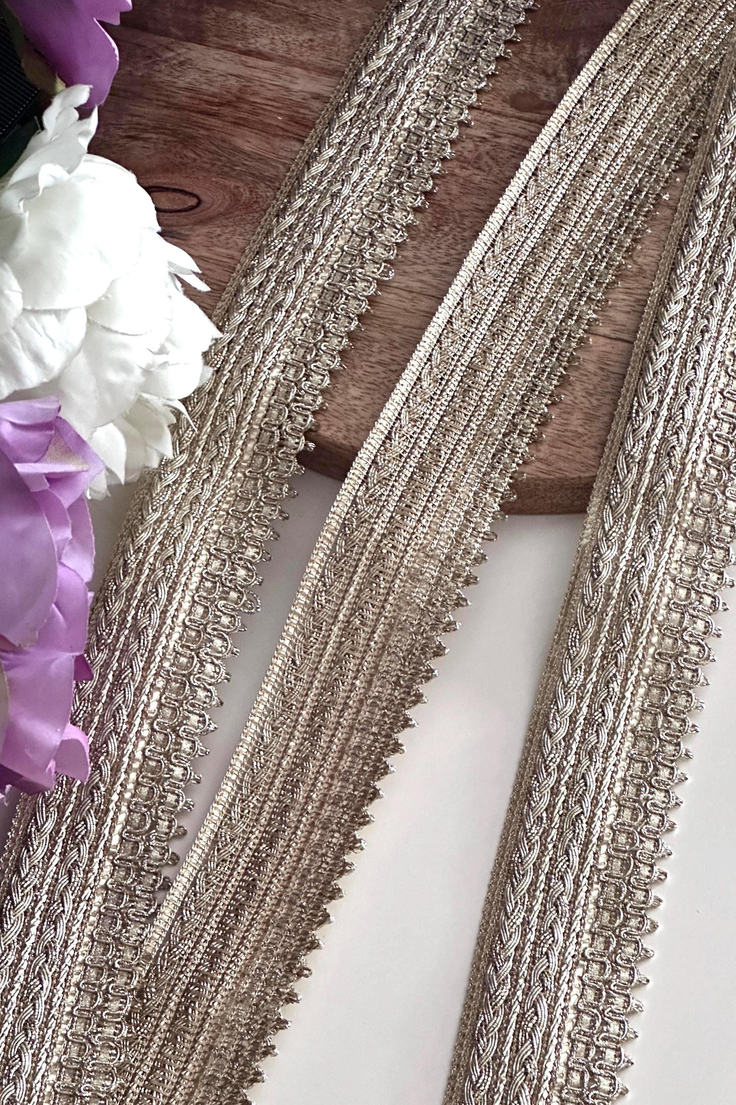 Elegant gold decorative trim with a textured finish for costumes and crafts.
Rolls of gold embroidered lace ribbon, perfect for sewing and embellishments.
Shimmering gold metallic trim displayed on fabric rolls for crafting and design