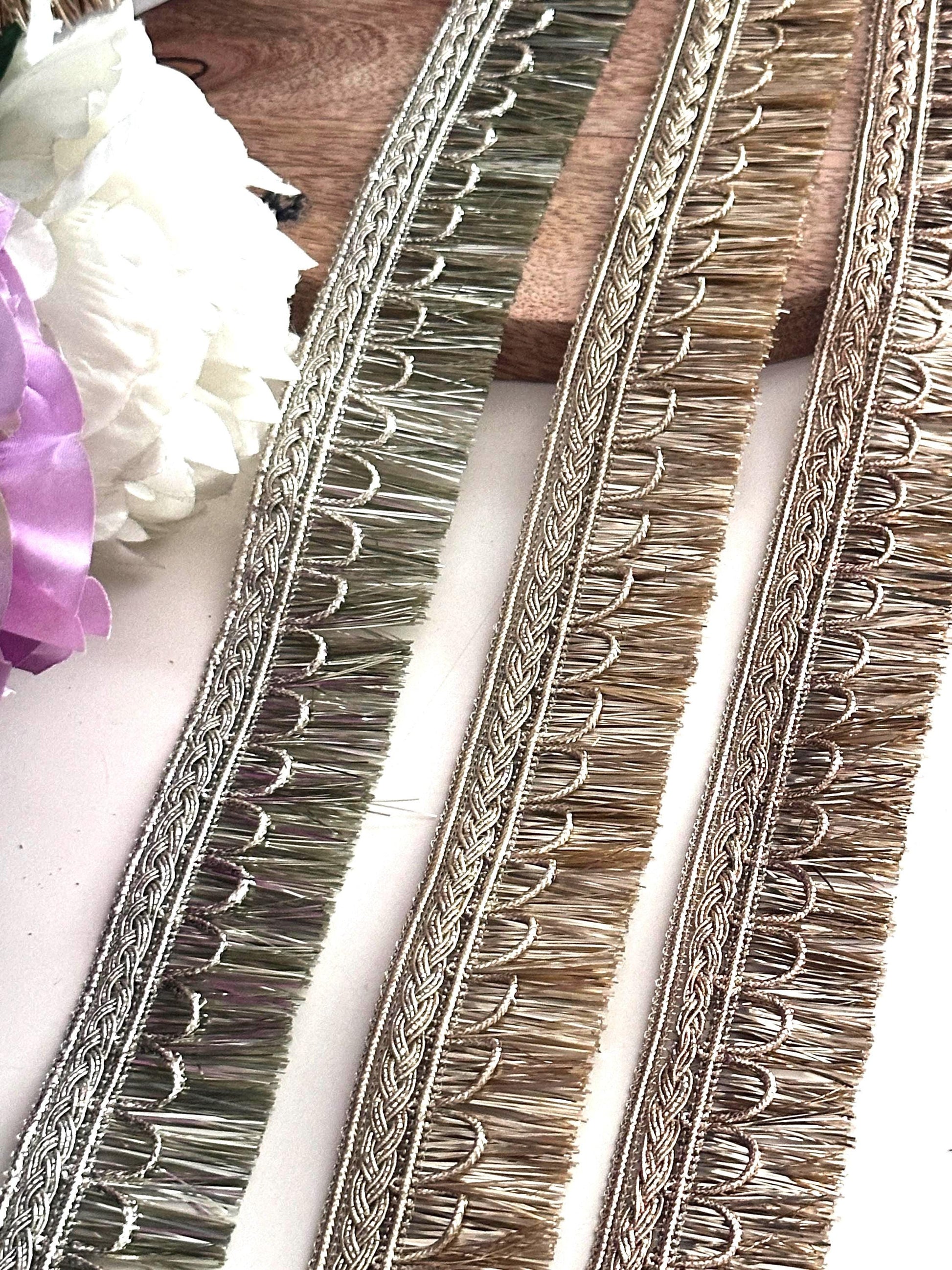 Elegant gold embroidered trim displayed on a spool for fabric embellishment and DIY crafts.