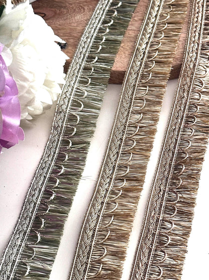 Elegant gold embroidered trim displayed on a spool for fabric embellishment and DIY crafts.