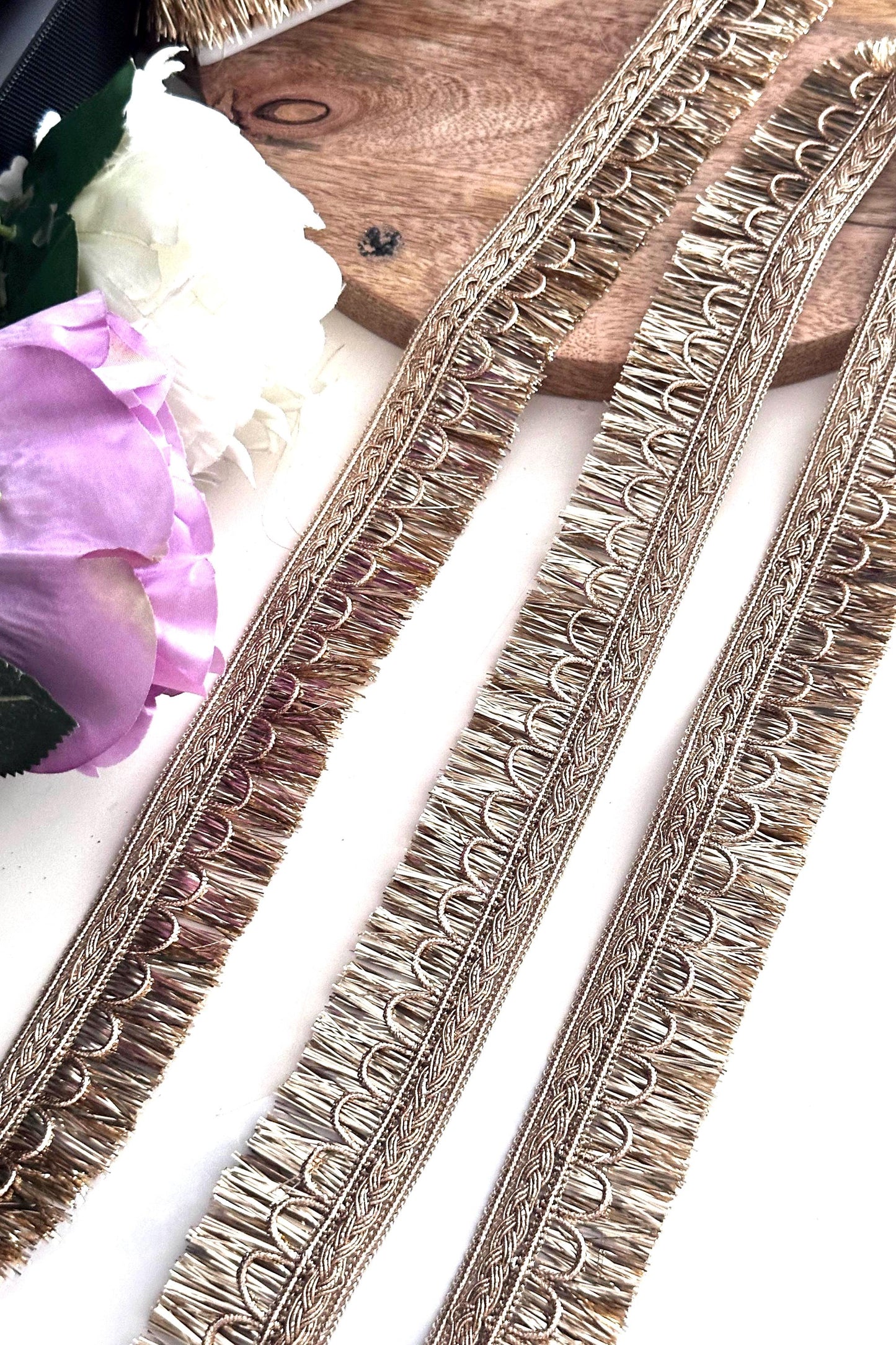 Decorative gold ribbon with embroidery details, perfect for creative sewing projects.
Rolls of gold lace ribbon used for crafting, wedding décor, and fashion accessories.
Elegant gold embroidered trim displayed on a spool for fabric embellishment and DIY crafts.
