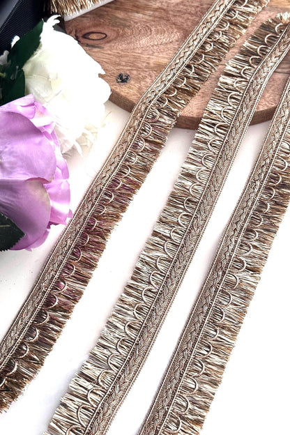 Decorative gold ribbon with embroidery details, perfect for creative sewing projects.
Rolls of gold lace ribbon used for crafting, wedding décor, and fashion accessories.
Elegant gold embroidered trim displayed on a spool for fabric embellishment and DIY crafts.